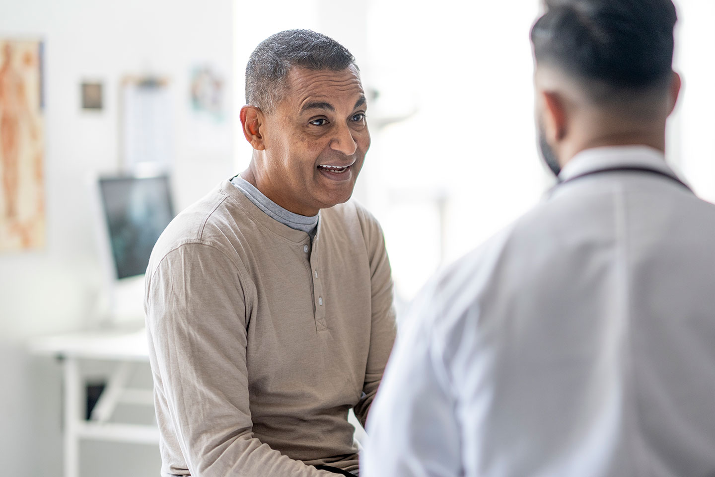 Older male patient in examining room with doctor